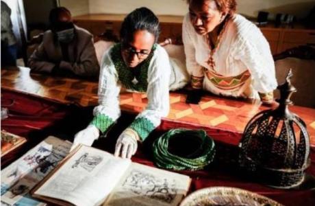 A conservator turns the pages of a book in the collection