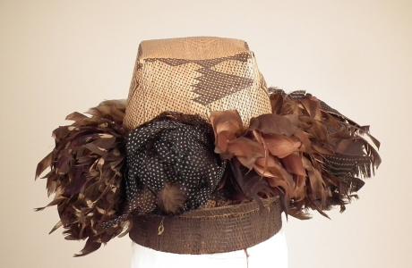 Plaited hat with bunches of feathers