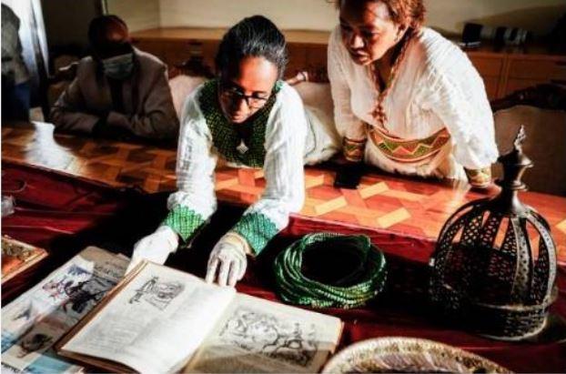 A conservator turns the pages of a book in the collection
