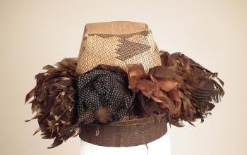 Plaited hat with bunches of feathers